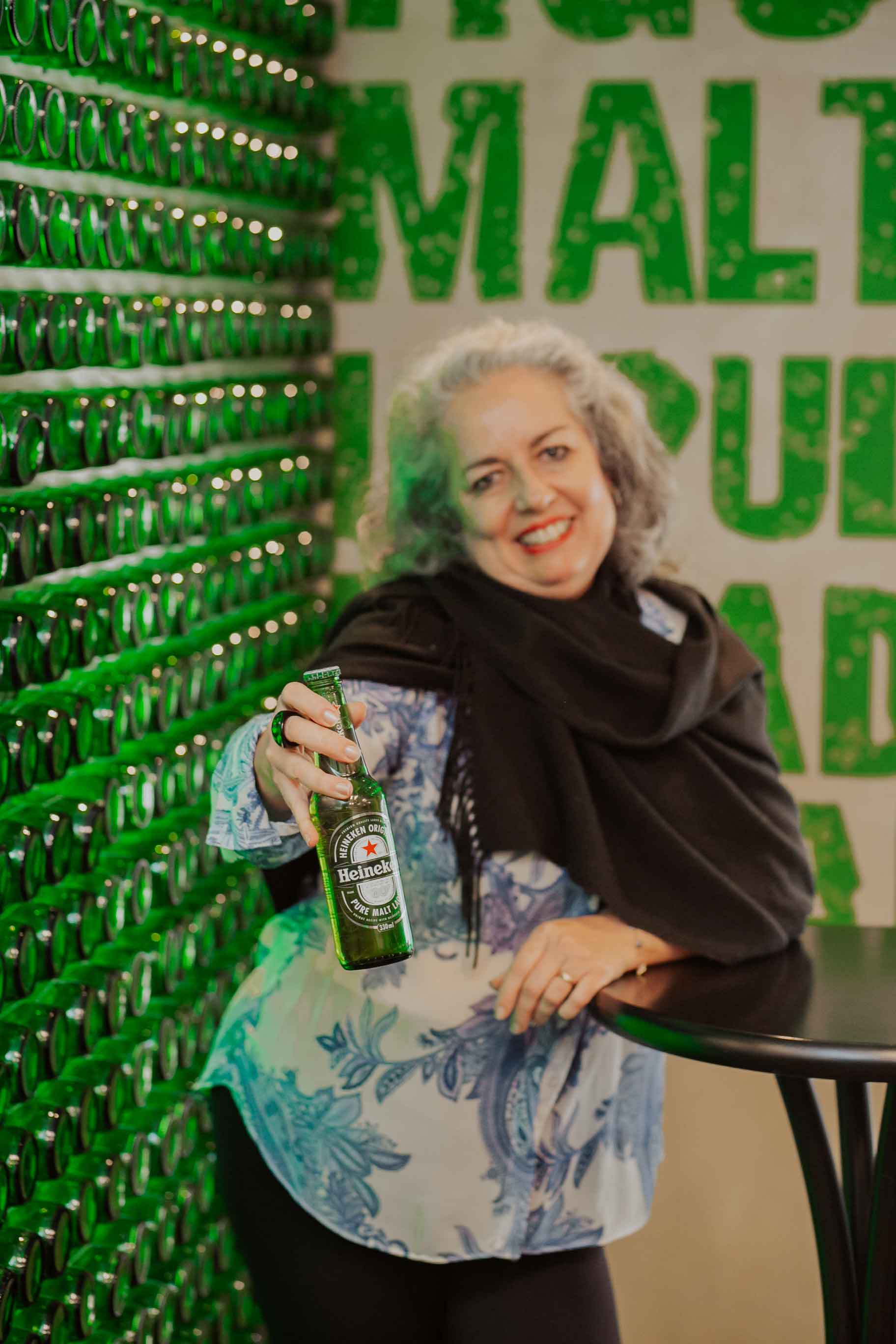 Mulher de cabelos brancos segurando Heineken
