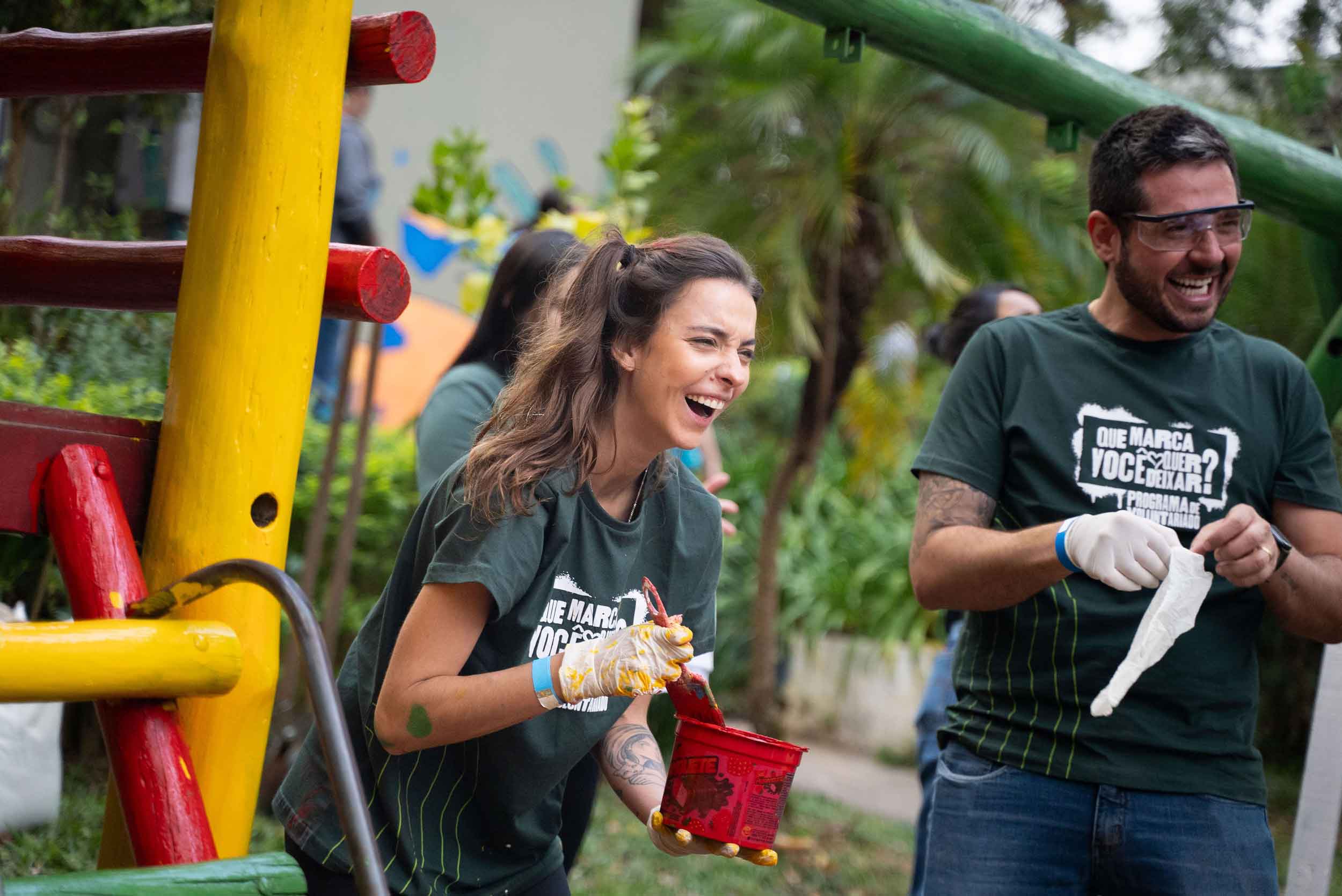Mulher sorrindo segurando balde de tinta 