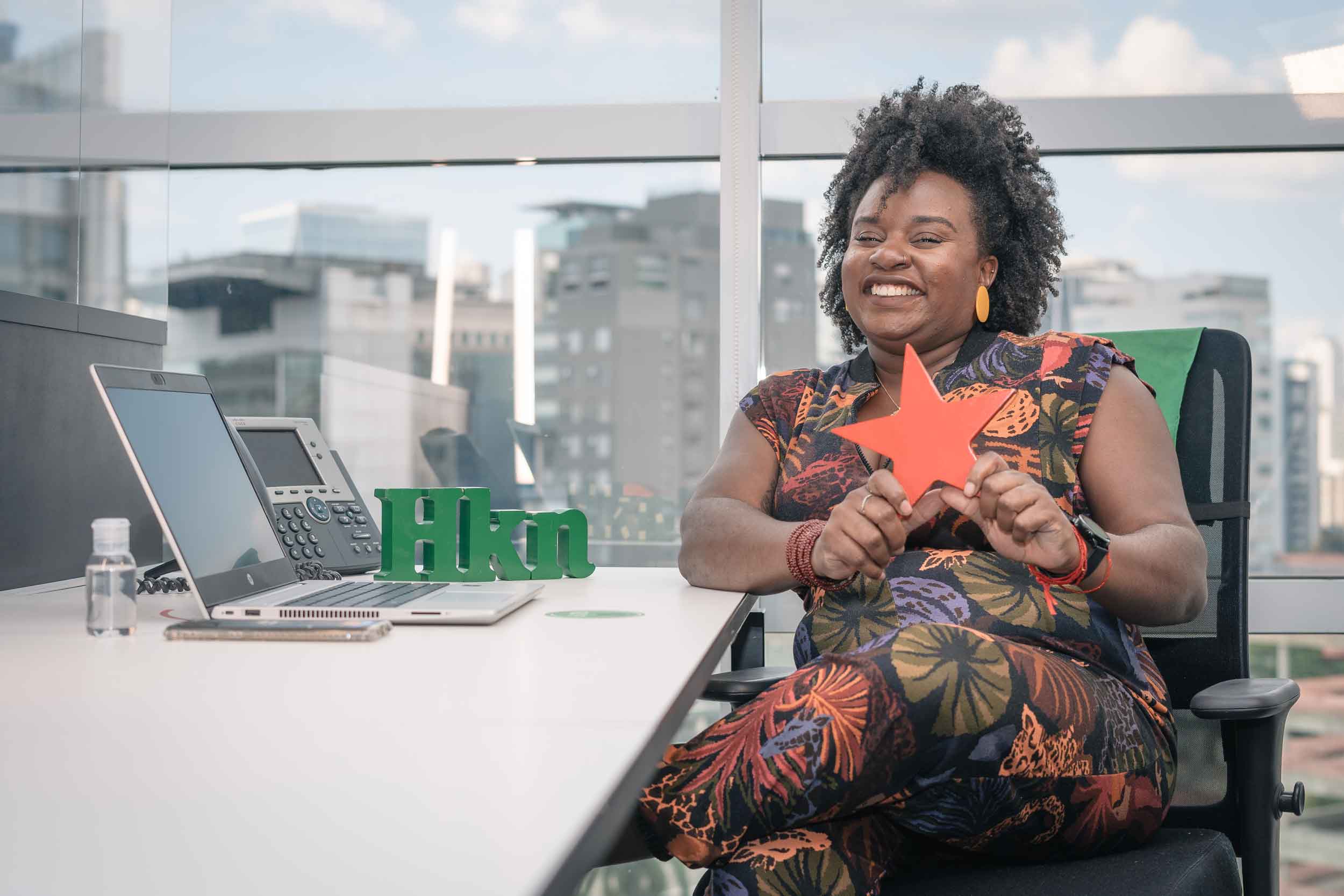 Mulher negra sorrindo e segurando estrela
